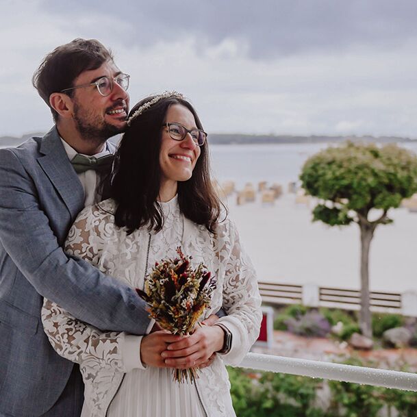 Hochzeitsshooting Kiel- Brautpaar auf Balkon im Hintergrund das Meer