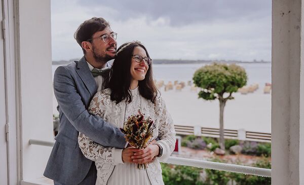 Hochzeitsshooting Kiel- Brautpaar auf Balkon im Hintergrund das Meer