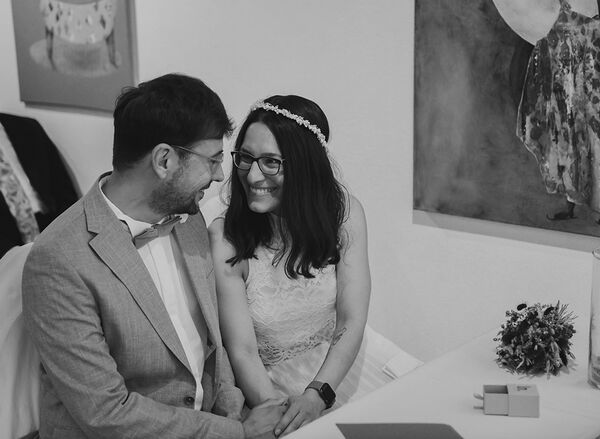 Schwarz-Weiß Aufnahme vom Brautpaar im Trauzimmer in Laboe. Sie lächeln sich an.