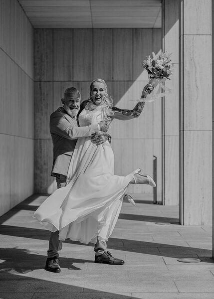 Braut springt in die Arme des Bräutigams.